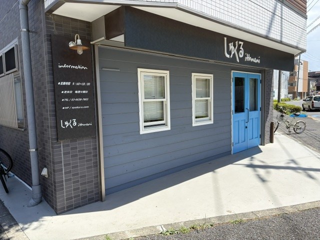 しゅくるithnaniの店舗外観。看板と青い扉が目印です。