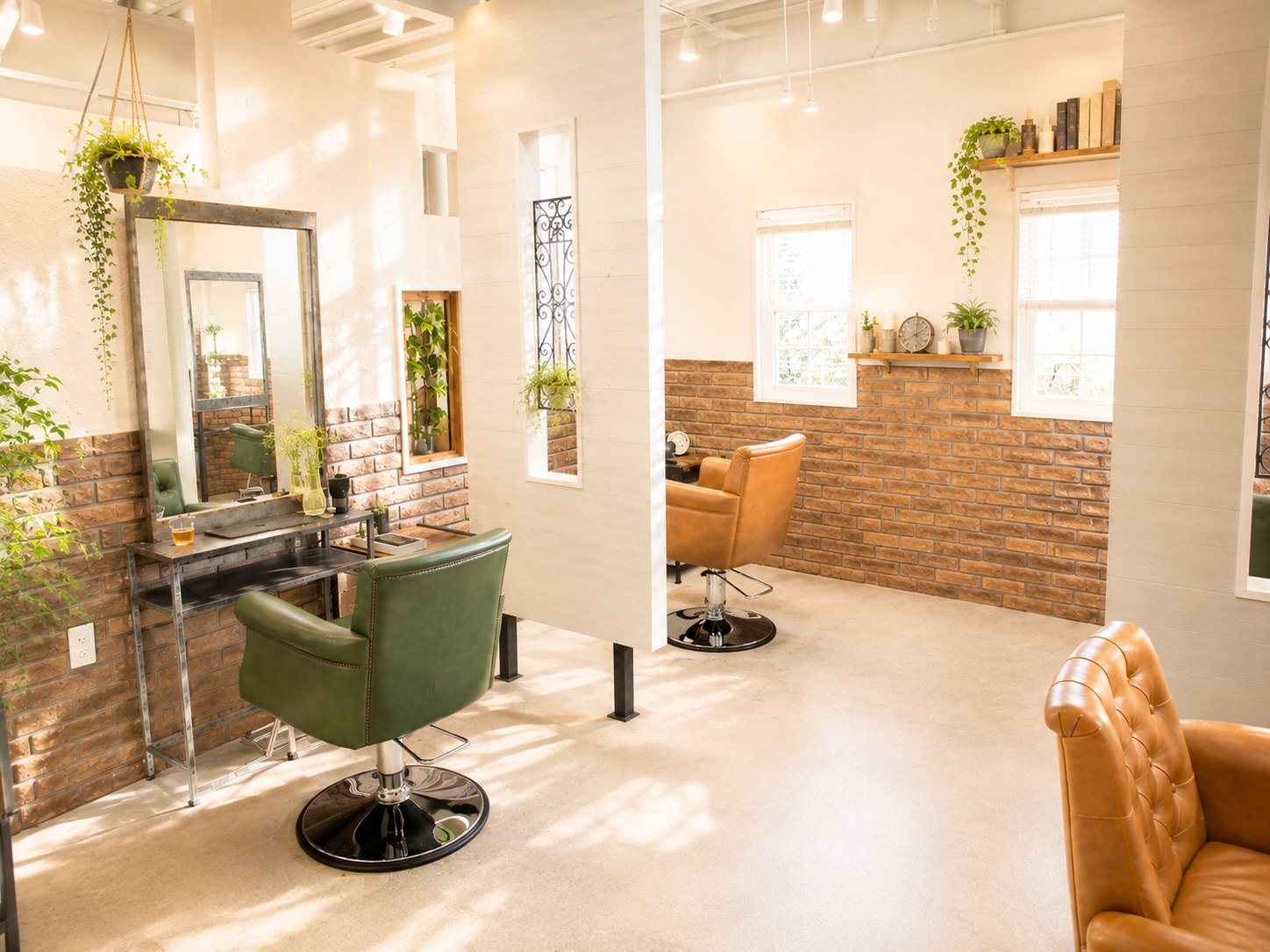しゅくるithnaniの明るい店内。グリーンのセット椅子と大型ミラー、レンガ調の壁。