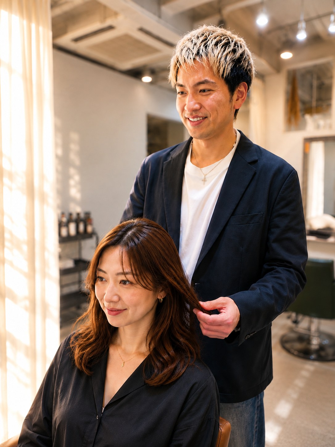 南里裕也（店長・スタイリスト）がお客様の髪を確認している様子
